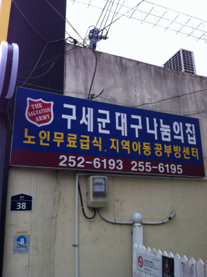 빨간색 자선냄비는 한겨울에 핀 노란 개나리꽃